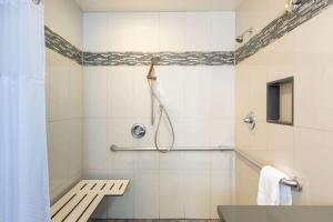 a bathroom with a shower and a bench in it at Days Inn by Wyndham Monterey-Fisherman's Wharf Aquarium in Monterey