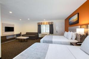 a hotel room with two beds and a flat screen tv at Days Inn by Wyndham Monterey-Fisherman's Wharf Aquarium in Monterey