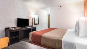 um quarto de hotel com uma cama e uma televisão de ecrã plano em Motel 6-Elk Grove Village, IL em Itasca