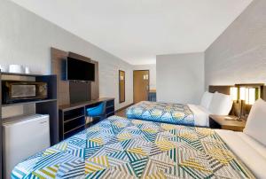 a hotel room with two beds and a flat screen tv at Motel 6-Cedar Rapids, IA - Airport in Cedar Rapids