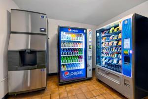 un distributore di bibite e un frigorifero in un negozio di Motel 6-Cedar Rapids, IA - Airport a Cedar Rapids