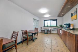 a kitchen and dining room with tables and chairs at Motel 6-Cedar Rapids, IA - Airport in Cedar Rapids