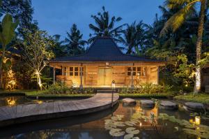 una casa de bambú con un estanque delante de ella en Korurua Dijiwa Ubud en Ubud