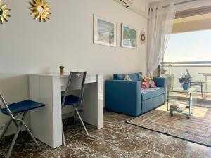 a living room with a blue couch and a desk at "Le Berkeley" Vue Mer, Centre, Parking in Menton