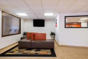 a waiting room with a leather chair and a flat screen tv at Motel 6-Prospect Heights, IL in Prospect Heights