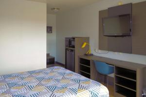 a bedroom with a bed and a desk with a television at Motel 6-Reno, NV - Livestock Events Center in Reno