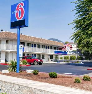 um sinal de motel em frente a um parque de estacionamento em Motel 6-Grants Pass, OR em Grants Pass