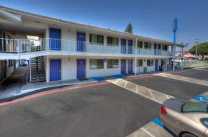 a building with blue doors and a parking lot at Motel 6-Tigard, OR - Portland South - Lake Oswego in Tigard