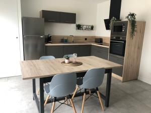 kuchnia z drewnianym stołem i 4 krzesłami w obiekcie Vimachlea w mieście Bourg-Saint-Christophe