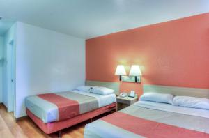 a motel room with two beds with orange walls at Motel 6-Tigard, OR - Portland South - Lake Oswego in Tigard +37 photos
