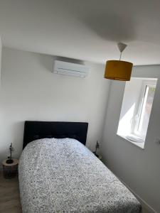 um quarto com uma cama num quarto branco em Vimachlea em Bourg-Saint-Christophe
