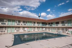 a large building with a swimming pool in front of it at Motel 6-Green River, UT in Green River