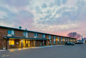 a brick building with a car parked in a parking lot at Motel 6-Oak Creek, WI in Oak Creek