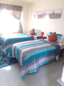two beds sitting in a room with at Cosy Beds Web in eMalahleni