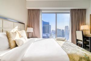 1 dormitorio con 1 cama grande, escritorio y ventana en Decadent 2BR in The Address Residences Dubai Marina by Deluxe Holiday Homes, en Dubái