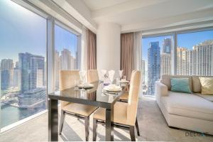 sala de estar con mesa y sofá en Decadent 2BR in The Address Residences Dubai Marina by Deluxe Holiday Homes, en Dubái
