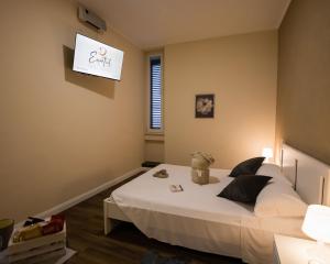 1 dormitorio con 1 cama blanca y un cartel en la pared en Essential Rooms, en Campobasso