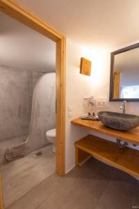a bathroom with a sink and a toilet and a mirror at Anamar Kea Boutique in Koundouros
