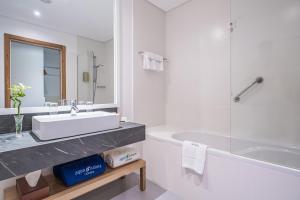 uma casa de banho branca com um lavatório e uma banheira em Aqua Natura Madeira em Porto Moniz