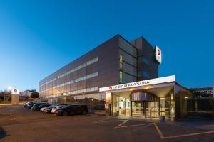 a large building with cars parked in a parking lot at Exe Zizur Pamplona in Zizur Mayor