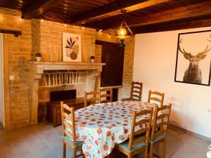 a dining room with a table and a fireplace at Gîte « Au petit Bonheur » in Orges