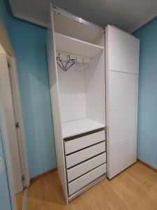 un armario con armarios blancos y una lámpara de araña en Apartamento Manuel Becerra, en Madrid