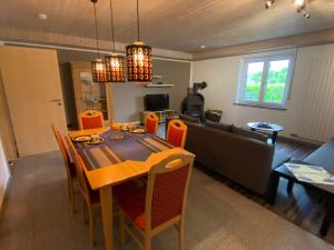 a dining room and living room with a table and chairs at Ferienwohnung Casa Herrmann in Losheim