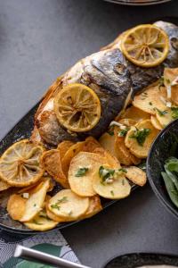 a plate of fish with lemon slices and chips at WhiteLace Resort in Jbeil