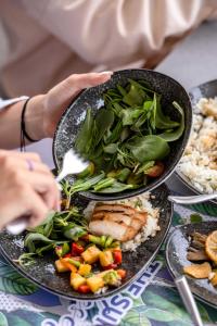 uma pessoa a comer comida numa mesa com pratos de comida em WhiteLace Resort em Jbeil