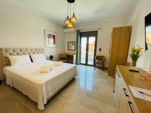 a bedroom with a large white bed with towels on it at XENIOS SUITES in Ligourio