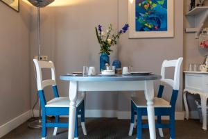 een blauwe tafel met stoelen en een vaas met bloemen bij Guesthouse Thoez in Maastricht