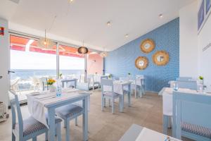 a dining room with tables and chairs with a view of the ocean at Aqua Natura Madeira in Porto Moniz