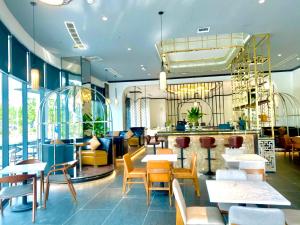 a restaurant with tables and chairs and a bar at NEWCC HOTEL AND SERVICED APARTMENT in Quang Ngai