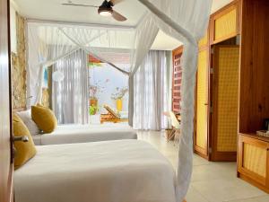 a bedroom with two beds and a window at Bahia Mar Boutique Hotel in Vilanculos