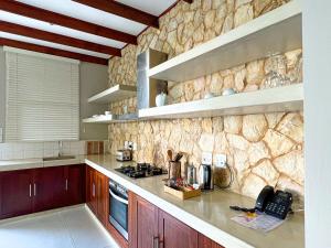 a kitchen with a stone wall at Bahia Mar Boutique Hotel in Vilanculos