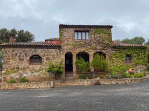 Kamienny dom z bluszczem rosnącym na nim w obiekcie Casas Rurales Monasterio de Rocamador w mieście Almendral
