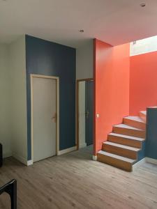 um quarto com uma escada com paredes cor de laranja e azul em DE LA CROIX em Nanterre