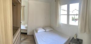 um quarto branco com uma cama e uma janela em DE LA CROIX em Nanterre