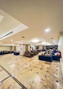 une grande chambre avec des canapés et des chaises dans un bâtiment dans l'établissement Al Tayseer Towers Tuwa Hotel فندق ابراج التيسير طوى, à La Mecque