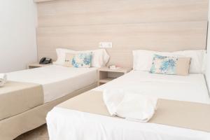 two beds in a room with white and blue pillows at Coral beach house & food in Playa de Palma