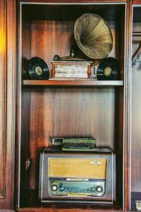 a wooden shelf with an old radio and a fan at Hotel Iliria in Shkodër