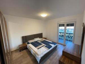 1 dormitorio con cama, mesa y ventana en ShooTer Apartments, en Ferizaj