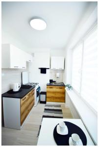 eine Küche mit weißen Geräten und einer schwarzen Arbeitsplatte in der Unterkunft Color24 Centrum Nisko in Nisko