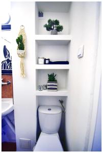 a bathroom with a toilet with white shelves at Color24 Centrum Nisko in Nisko