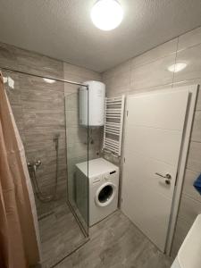 a small bathroom with a washing machine and a toilet at ShooTer Apartments in Ferizaj