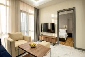 un soggiorno con TV, divano e tavolo di Hilltop North Avenue by Stellar Hotels, Yerevan a Yerevan