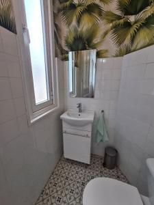 La salle de bains est pourvue de toilettes blanches et d'un lavabo. dans l'établissement 122A - Emblemática vivienda en Playa San Lorenzo, à Gijón