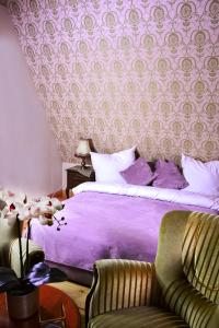 a bedroom with a purple bed and a chair at Rezydencja Lawendowe Wzgórze in Zachełmie