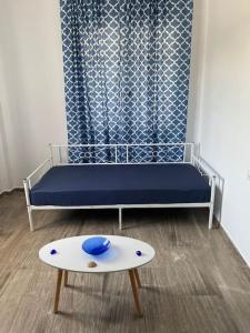 a room with a bed and a table in front of a window at Κατοικία 80 τ.μ. δίπλα από την θάλασσα στην Ελιά. in Elia Laconias