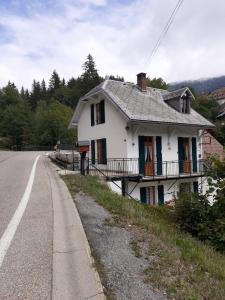 una casa blanca al lado de una carretera en Maison du Guier 46 personne au coeur du massif, en Saint-Pierre-de-Chartreuse